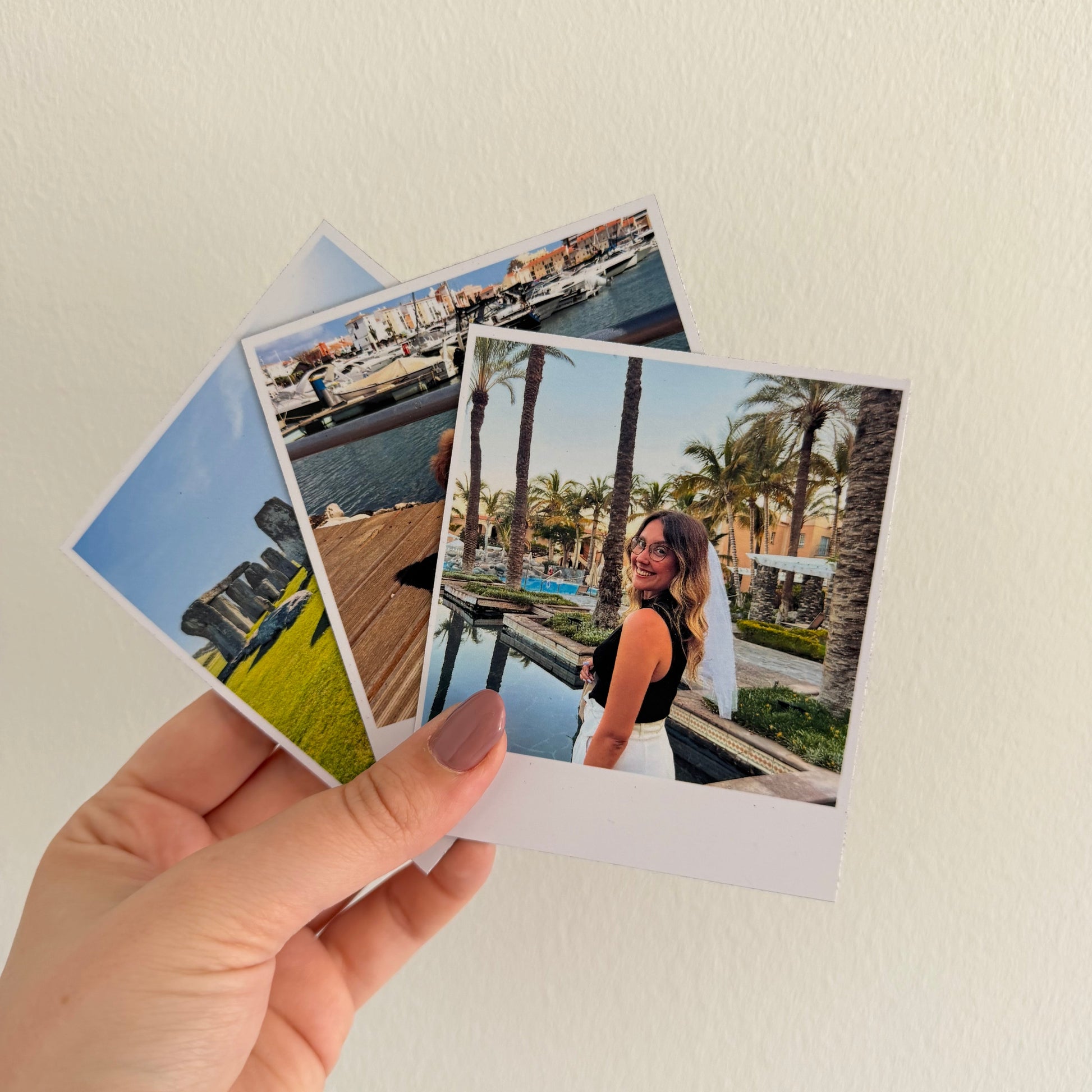 mão a segurar ímanes personalizados em formato polaroid com fotografias de momentos especiais.