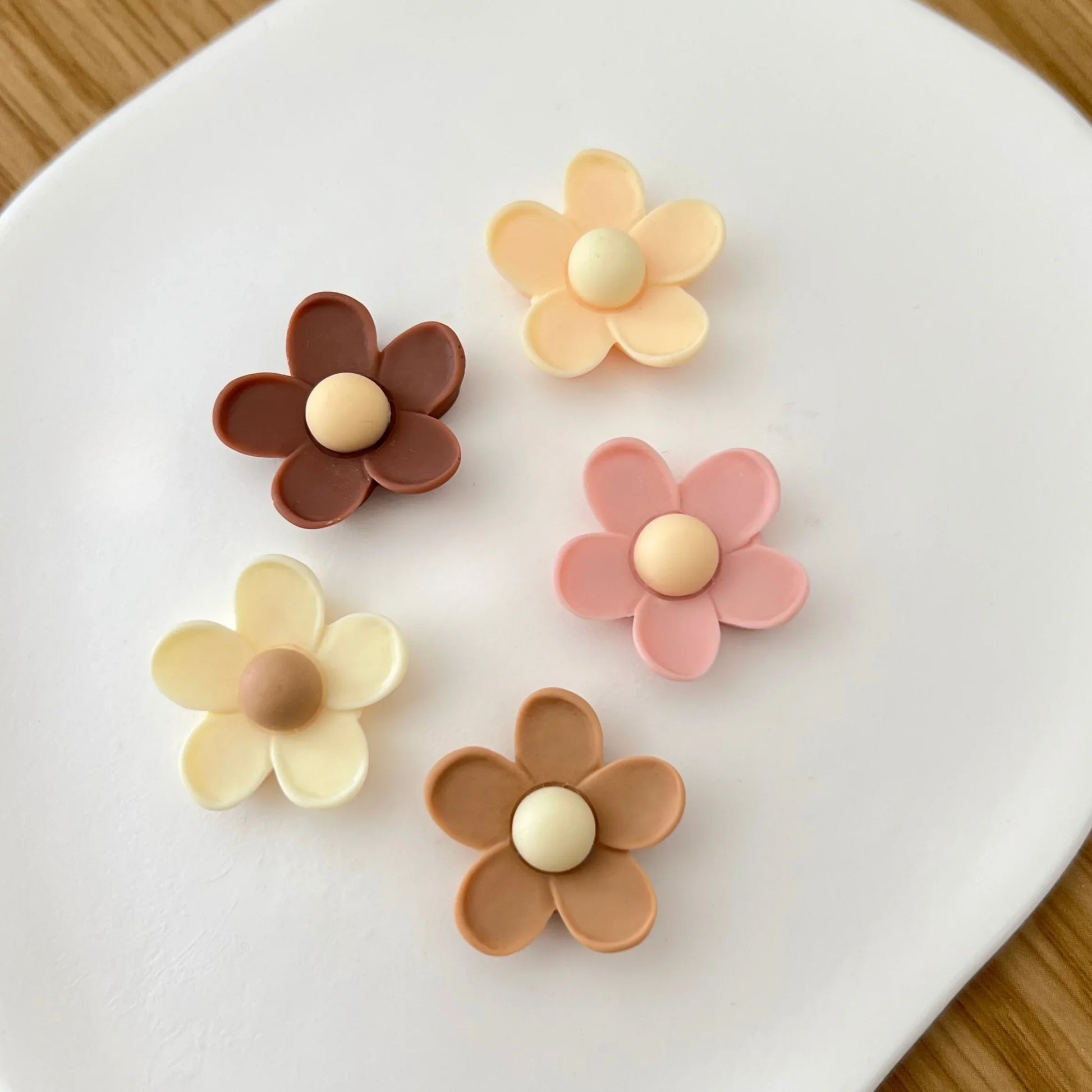 Detalhe de mini ímanes decorativos em forma de flor, textura e acabamento