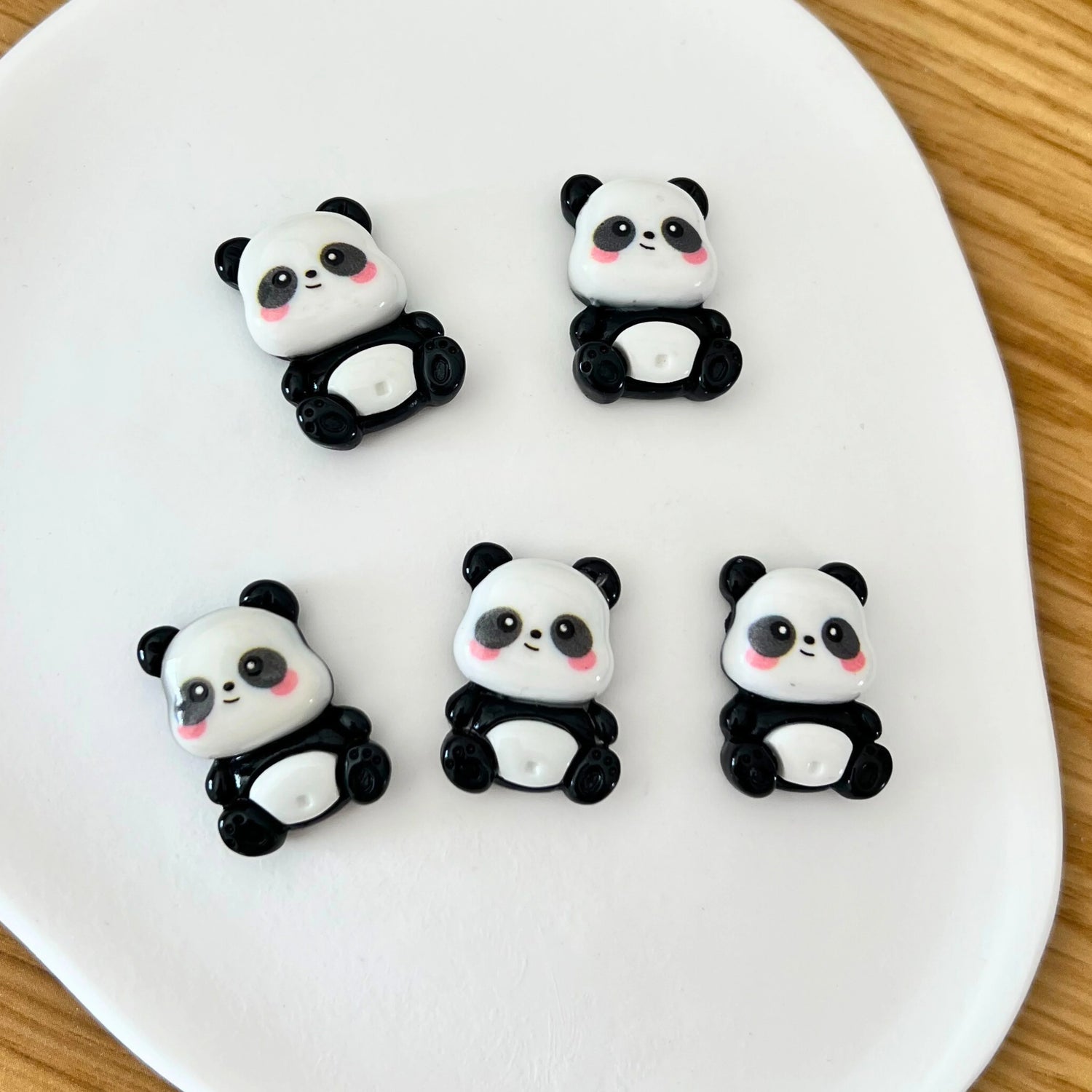 Conjunto de mini ímanes decorativos em forma de panda sobre prato branco